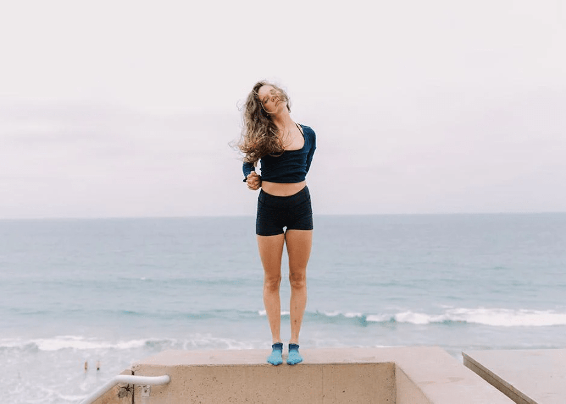 woman in workout clothes at the beach