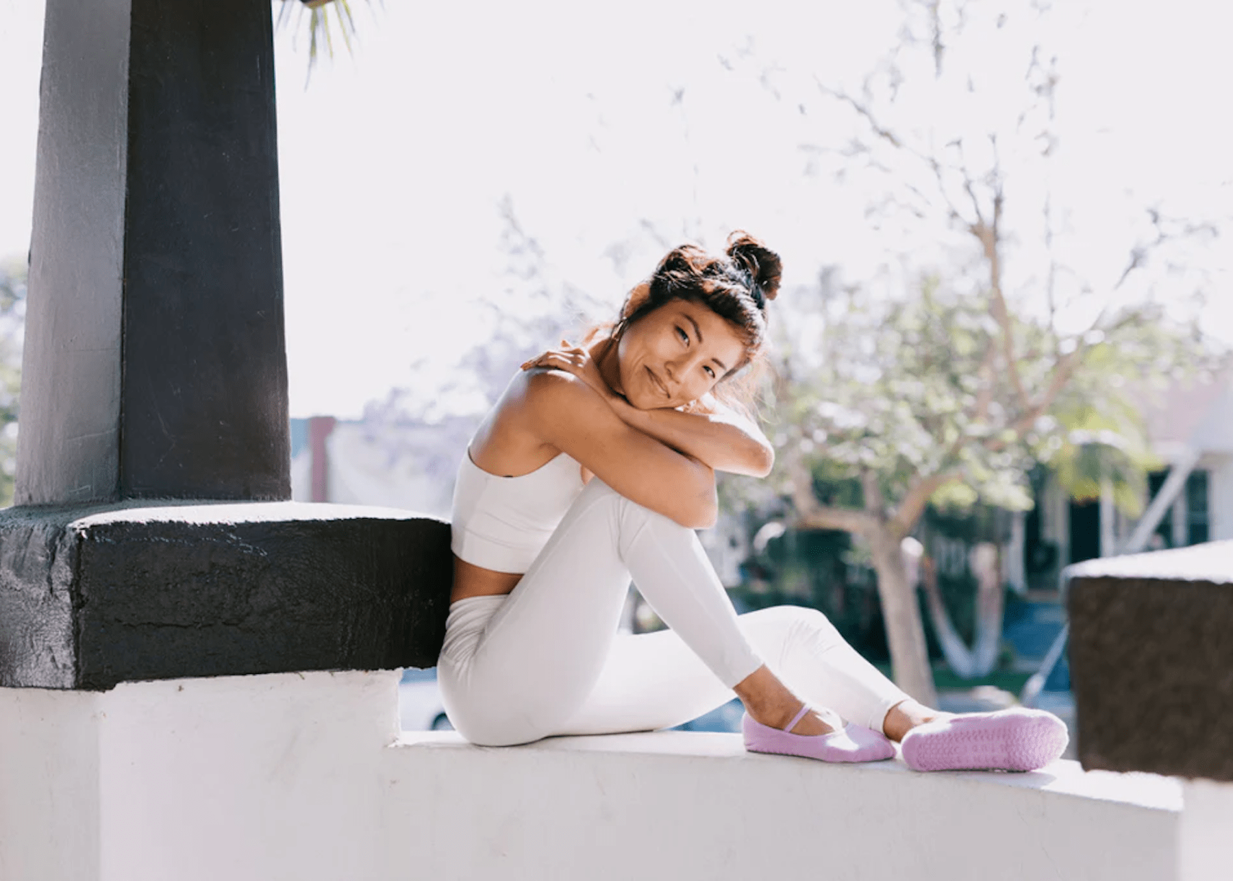 woman in white workout clothes and pink grip socks