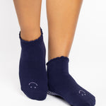 Women wearing dark purple grip socks with white face for Pilates, Barre, Yoga, and beyond. 