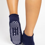 Women wearing dark purple grip socks with white face for Pilates, Barre, Yoga, and beyond. 