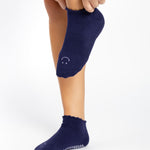 Women wearing dark purple grip socks with white face for Pilates, Barre, Yoga, and beyond. 