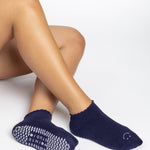 Women wearing dark purple grip socks with white face for Pilates, Barre, Yoga, and beyond. 
