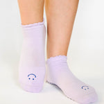 Women wearing lavender grip socks with white purple face for Pilates, Barre, Yoga, and beyond. 