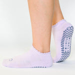 Women wearing lavender grip socks with white purple face for Pilates, Barre, Yoga, and beyond. 