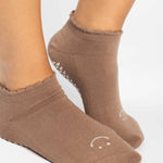 Women wearing brown beige grip socks with white smiley face for Pilates, Barre, Yoga, and beyond. 