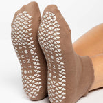 Women wearing brown beige grip socks with white smiley face for Pilates, Barre, Yoga, and beyond. 