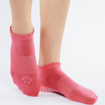 Women wearing pink grip socks with white smiley face for Pilates, Barre, Yoga, and beyond. 