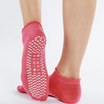 Women wearing pink grip socks with white smiley face for Pilates, Barre, Yoga, and beyond. 