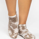 Woman wearing a tan full foot grip sock with it tie dyed brown, made for pilates, barre, yoga, and beyond.  