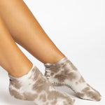 Woman wearing a tan full foot grip sock with it tie dyed brown, made for pilates, barre, yoga, and beyond.  