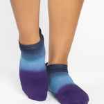 Women wearing a navy blue, light blue, and purple ombre full foot grip sock made for pilates, yoga, barre, and beyond.