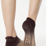 Women wearing a dark brown, light brown, and tan ombre full foot grip sock made for pilates, yoga, barre, and beyond.