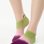 Women wearing a green, pink, and purple ombre full foot grip sock made for pilates, yoga, barre, and beyond.