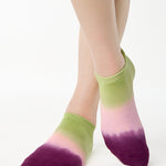 Women wearing a green, pink, and purple ombre full foot grip sock made for pilates, yoga, barre, and beyond.