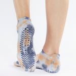 Woman wearing a orange and lavender tie dye grip socks. Made for pilates, barre, yoga, and beyond. 