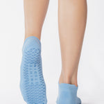 Women wearing a solid light blue full foot grip sock made for Pilates, Barre, Yoga, and beyond. 