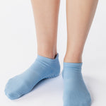 Women wearing a solid light blue full foot grip sock made for Pilates, Barre, Yoga, and beyond. 
