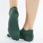 Women wearing a solid sage green full foot grip sock made for Pilates, Barre, Yoga, and beyond. 