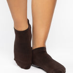 Women wearing a solid dark brown full foot grip sock made for Pilates, Barre, Yoga, and beyond. 