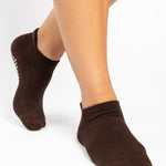 Women wearing a solid dark brown full foot grip sock made for Pilates, Barre, Yoga, and beyond. 