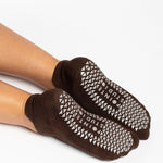 Women wearing a solid dark brown full foot grip sock made for Pilates, Barre, Yoga, and beyond. 