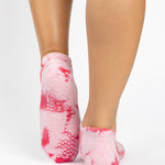 Woman wearing a tan full foot grip sock with it dip dyed with light and hot pink, made for pilates, barre, yoga, and beyond.  