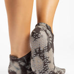 Woman wearing a tan full foot grip sock with it dip dyed with light and dark brown, made for pilates, barre, yoga, and beyond.  