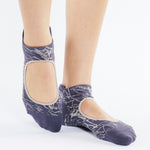 Womean wearing an amethyst purple grip socks with white squiguilly lines. Made for pilates, barre, yoga, and beyond. 