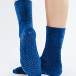 Women wearing dark blue fuzzy plush crew grip socks with a white happy face for recovery and relaxing.  