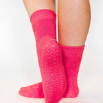 Women wearing watermelon fuzzy plush crew grip socks with a white happy face for recovery and relaxing.  