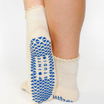 Women wearing off white ankle grip socks with blue happy face for Pilates, Barre, Yoga, and beyond. 