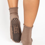 Women wearing brown ankle grip socks with black happy face for Pilates, Barre, Yoga, and beyond. 