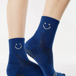 Women wearing navy blue ankle grip socks with white happy face for running. 