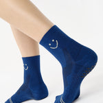 Women wearing navy blue ankle grip socks with white happy face for running. 
