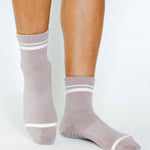 Women wearing a solid light purple ankle grip sock with white stripes on the toes and top ankle cuff made for Pilates, Barre, Yoga, and beyond. 