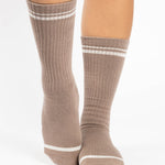 Women wearing a taupe brown crew grip sock with white stripes on the toes and top ankle cuff made for Pilates, Barre, Yoga, and beyond. 