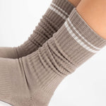Women wearing a taupe brown crew grip sock with white stripes on the toes and top ankle cuff made for Pilates, Barre, Yoga, and beyond. 