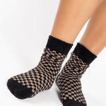 Woman wearing black and brown crew ultra plush soft grip socks made for recovery, post pilates, barre, yoga, and beyond.