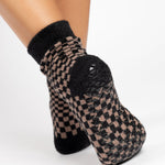 Woman wearing black and brown crew ultra plush soft grip socks made for recovery, post pilates, barre, yoga, and beyond.