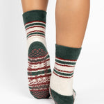 Woman wearing festive white with green and red striped crew ultra plush soft grip socks made for recovery, post pilates, barre, yoga, and beyond.