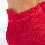 Women wearing red smiley face patterned grip socks made for Pilates, Barre, Yoga, and beyond. 