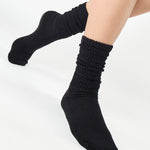 Women wearing a black mid-weight knit grip sock that scrunches, made for Pilates, Barre, Yoga, and Beyond. 
