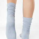 Women wearing a light blue mid-weight knit grip sock that scrunches, made for Pilates, Barre, Yoga, and Beyond. 