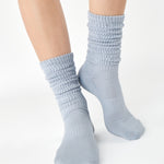 Women wearing a light blue mid-weight knit grip sock that scrunches, made for Pilates, Barre, Yoga, and Beyond. 