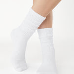 Women wearing a white mid-weight knit grip sock that scrunches, made for Pilates, Barre, Yoga, and Beyond. 