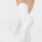 Women wearing a white mid-weight knit grip sock that scrunches, made for Pilates, Barre, Yoga, and Beyond. 
