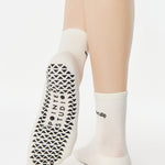 Women wearing a solid white ankle grip sock with "don't slip" on the ankle made for Pilates, Barre, Yoga, and beyond. 