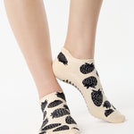Women wearing a white full foot grip sock with black strawberries all around. 