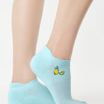 Women wearing a light blue full foot grip sock with a yellow lemon motif near the cuff made for Pilates, Barre, Yoga, and beyond. 