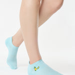 Women wearing a light blue full foot grip sock with a yellow lemon motif near the cuff made for Pilates, Barre, Yoga, and beyond. 